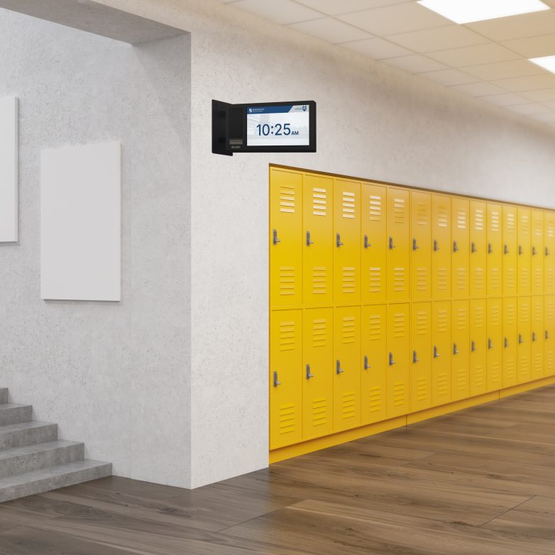 Image of an Algo 8420 display speaker which is double-sided and mounted to a wall in the hallway of a school displaying the time.