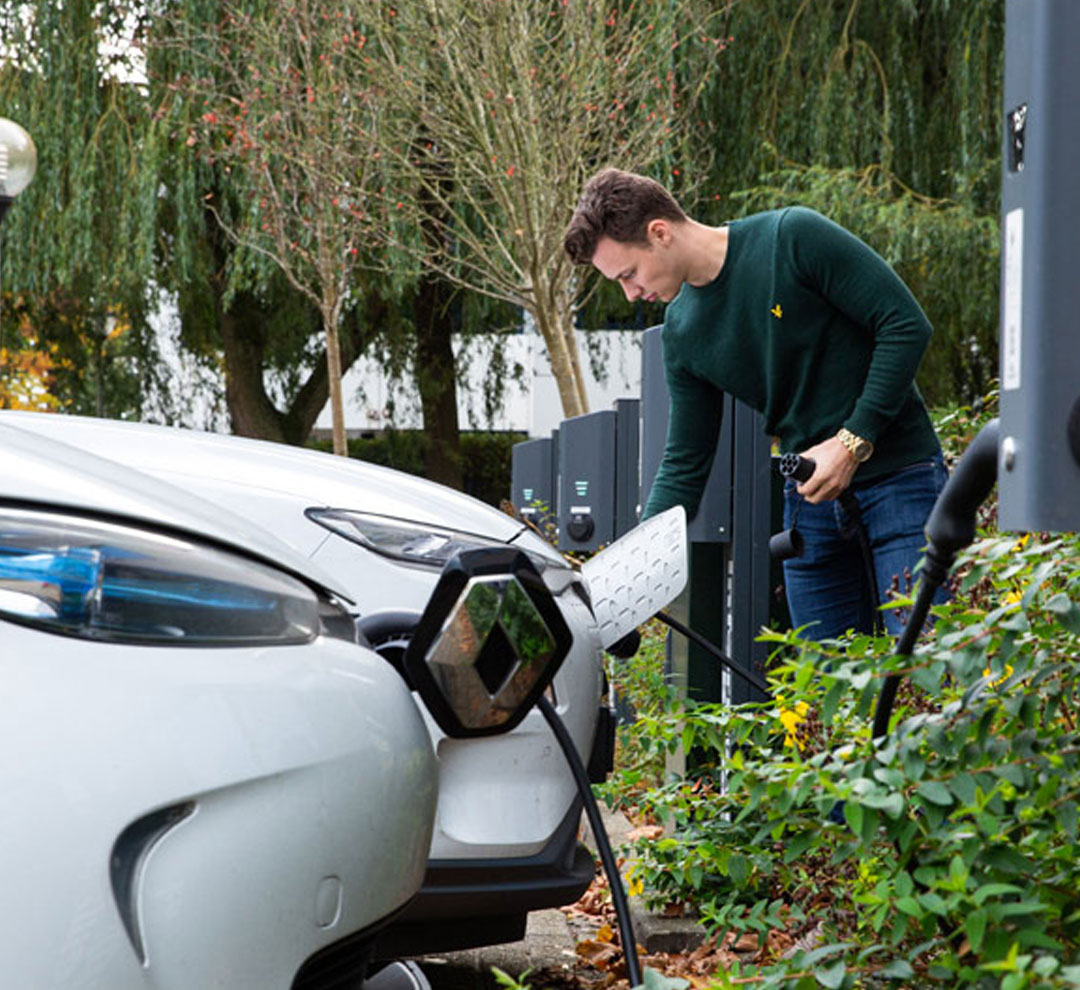 Man charging its electric vehicle at a charging point