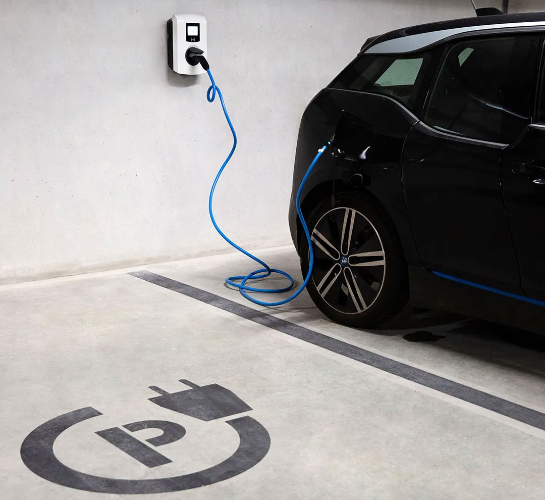 An electric car charging at a charging point in a parking garage