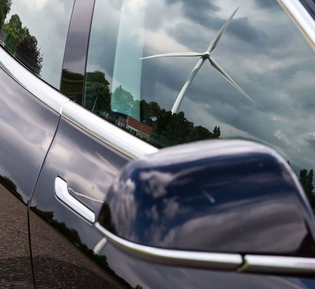 electric car with a reflection of a windmill in its window