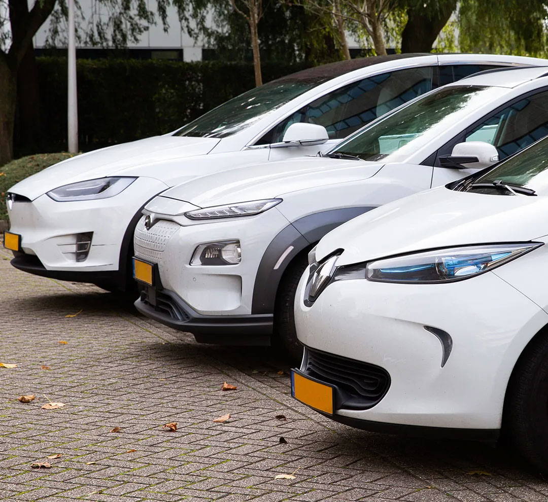 Three electric cars standing in a parking lot