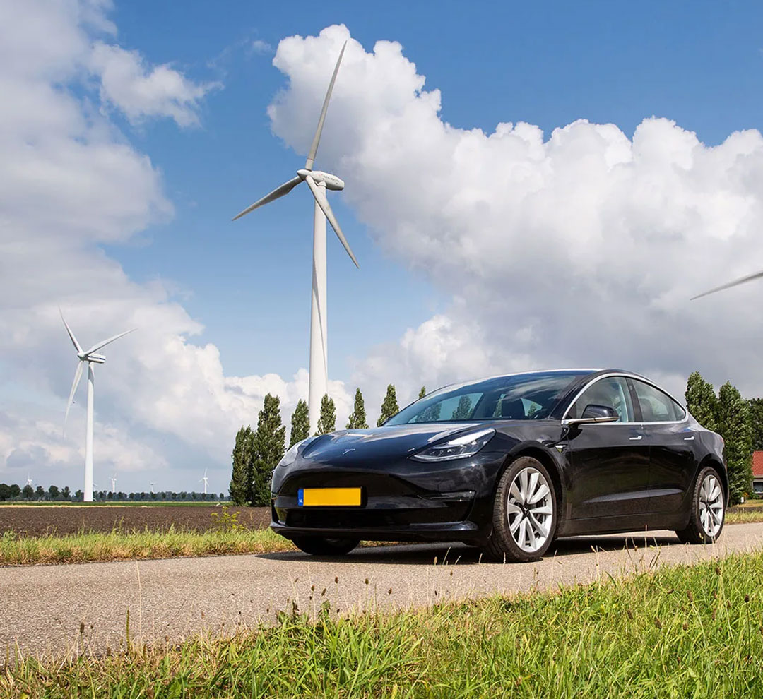 electric car standing on the road in front of a windmill