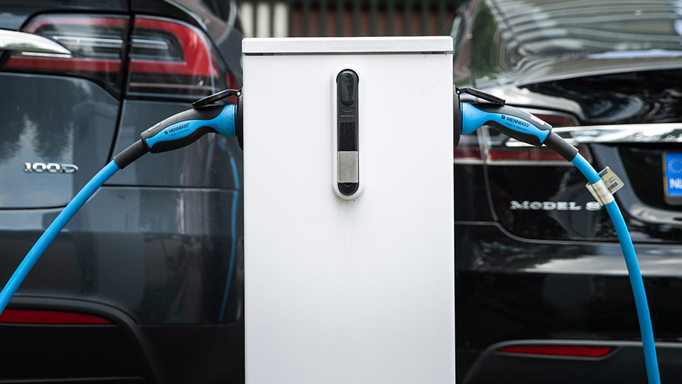 rear view of two charging electric cars and charge station
