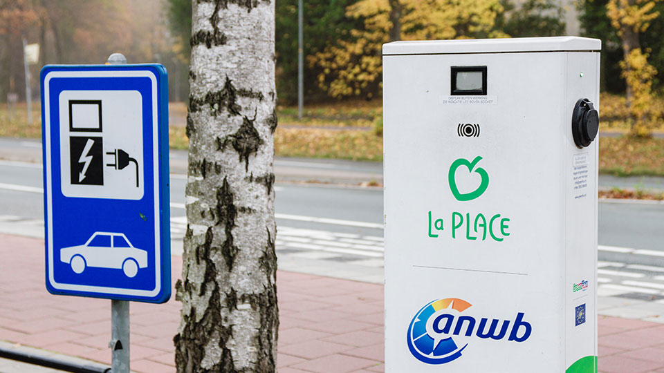 La place charging point with a charging sign next to it