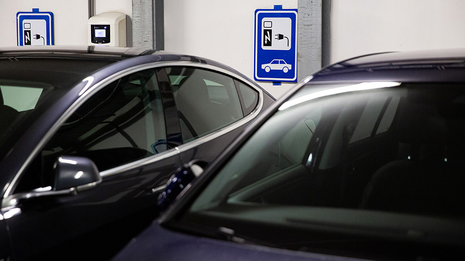 Two electric vehicles charging in a parking garage